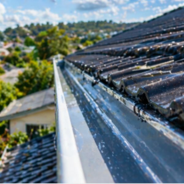 Clean residential roof gutter with clear water flow and well-maintained roofing system